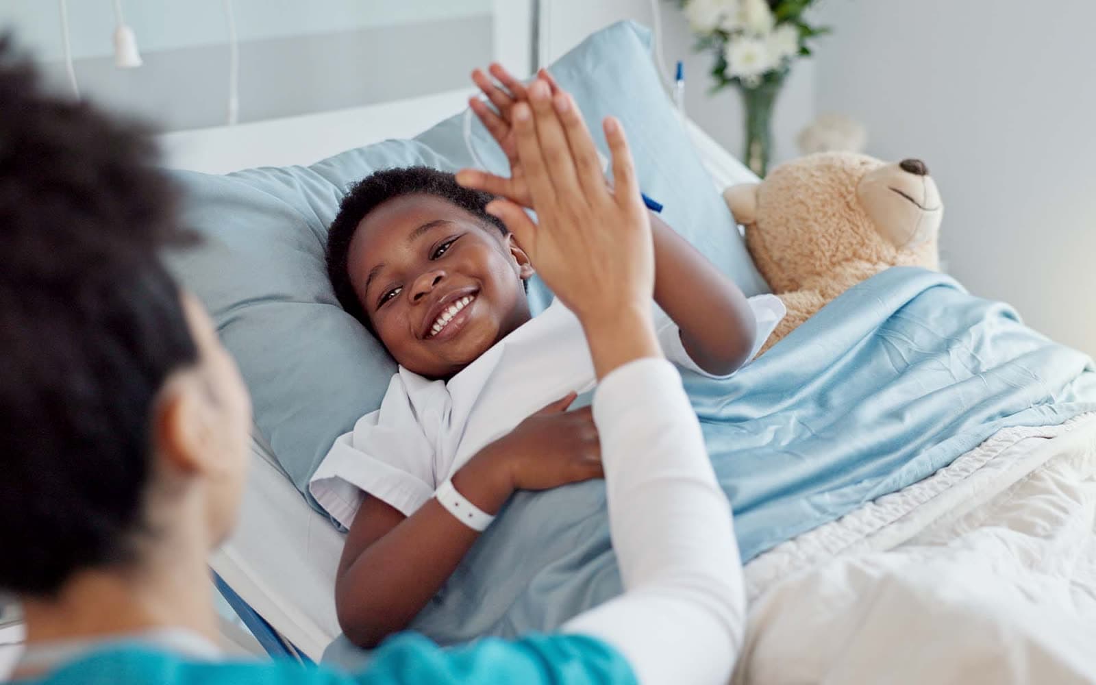 High five, nurse and black child patient in hospital for success of surgery for congenital heart disease. Checkup, sick and cardiology medical worker with African kid in bed for postoperative care.