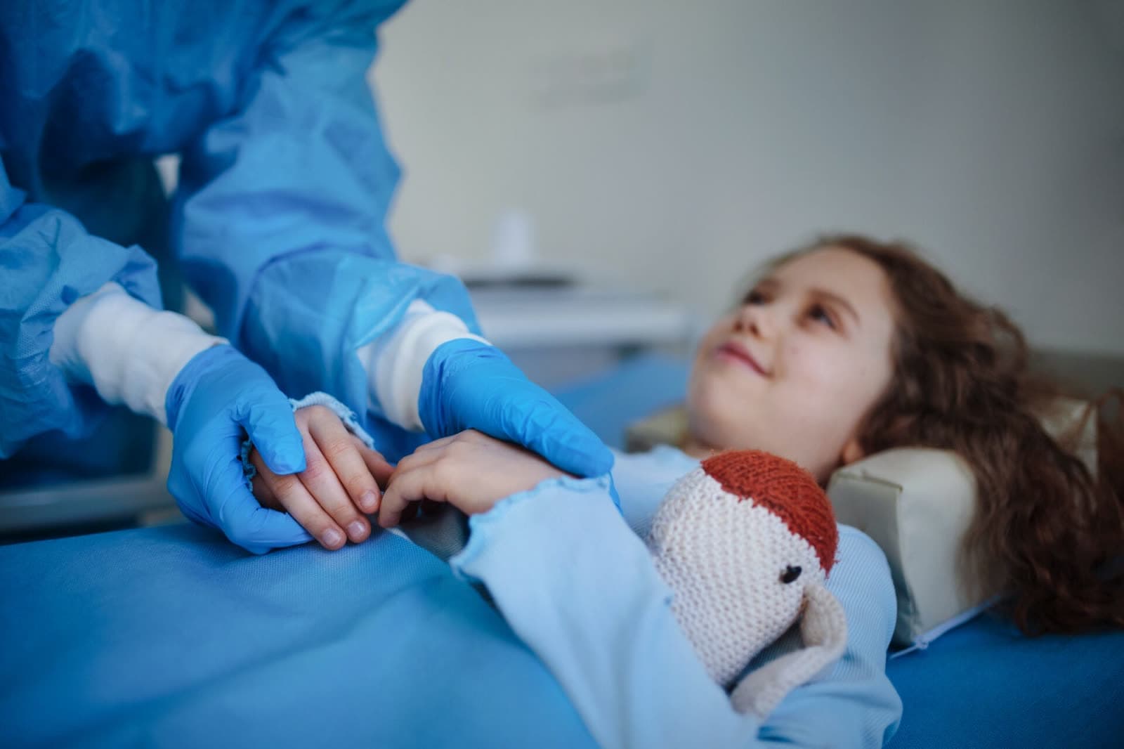 close up of doctor taking care of little girl in hospital ward after dermoid cyst surgery.