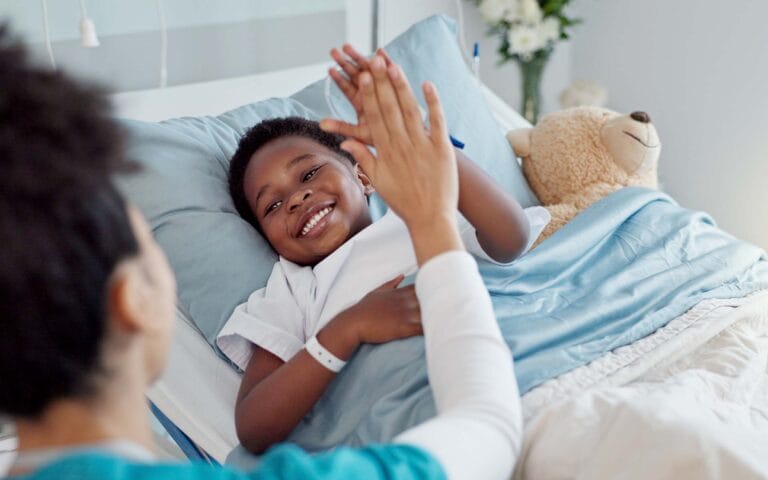 High five, nurse and black child patient in hospital for success of surgery for congenital heart disease. Checkup, sick and cardiology medical worker with African kid in bed for postoperative care.
