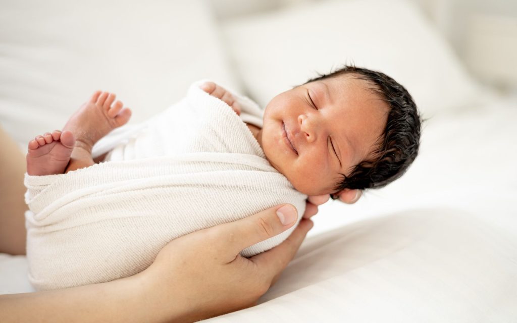 Infant wrapped in a blanket waiting for their infant circumcision