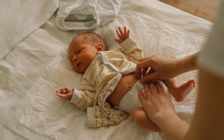 Baby being changed on a bed. Pediatric Colorectal Surgery